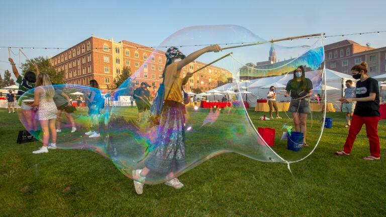 A female student makes large bubbles during the residential new student welcome dinner.