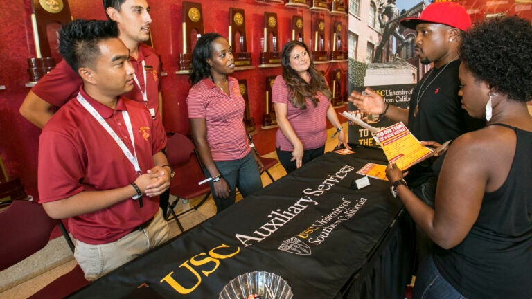 USC Auxiliary Service representatives working at a booth for a job fair.