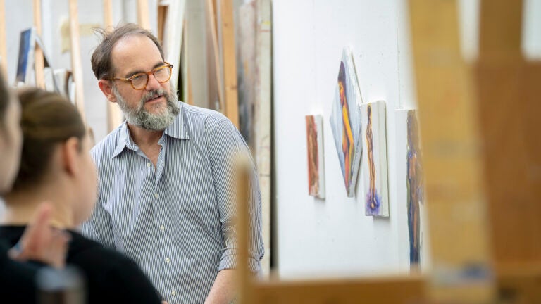 Professor discussing art piece with students.