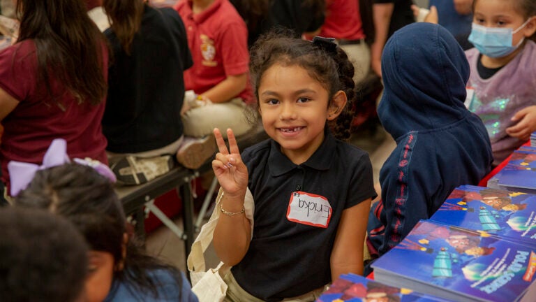Child making peace sign at camera
