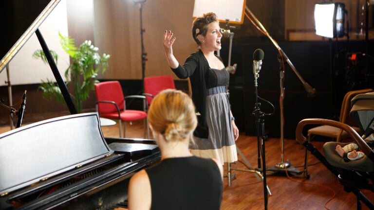 Women singing in room with accompanying piano