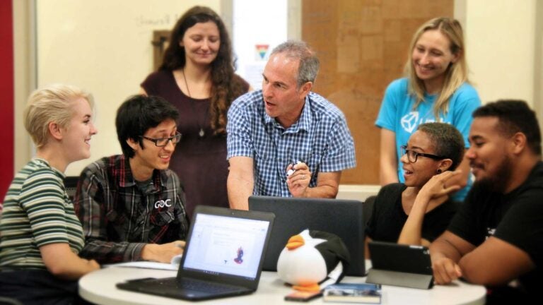 Professor speaking to students around a table