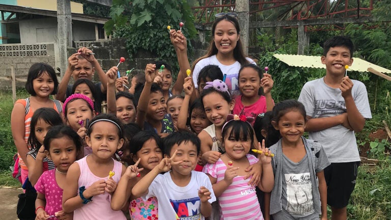 A USC student poses with a group of children from an orphanage she built in the Philippines through the USC Dornsife College of Letters, Arts and Sciences.