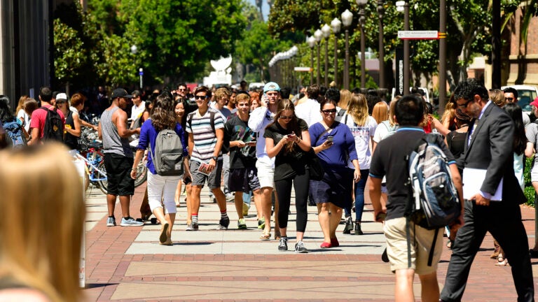 Kids walking along the walkway in the center of UPC campus.