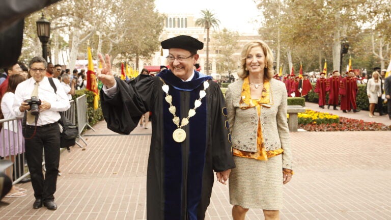 President Nikias showing the fight on sign as he walks with his wife for his inauguration