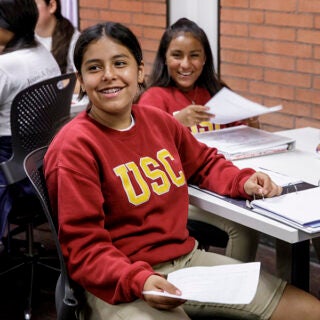 An elementary student smiles at the camera duringUSC McMorrow Neighborhood Academic Initiative Saturday Academy kickoff