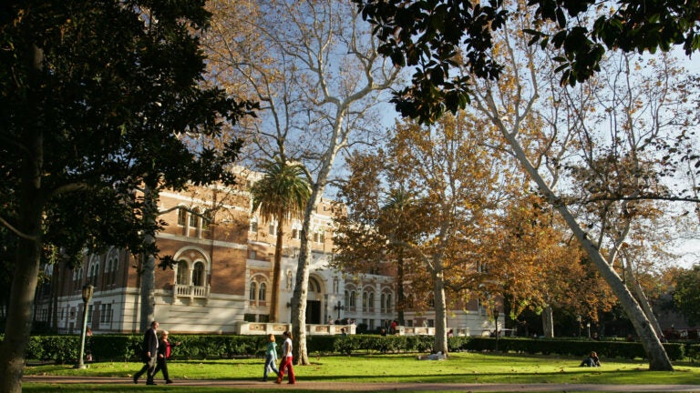 The front of a building on UPC campus with students walking across the lawn.