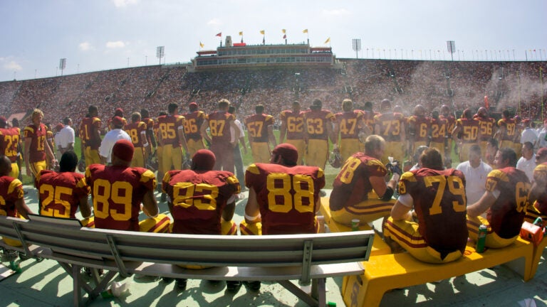 Members of USC's Trojan Football team gather along the sidelines before entering the game.