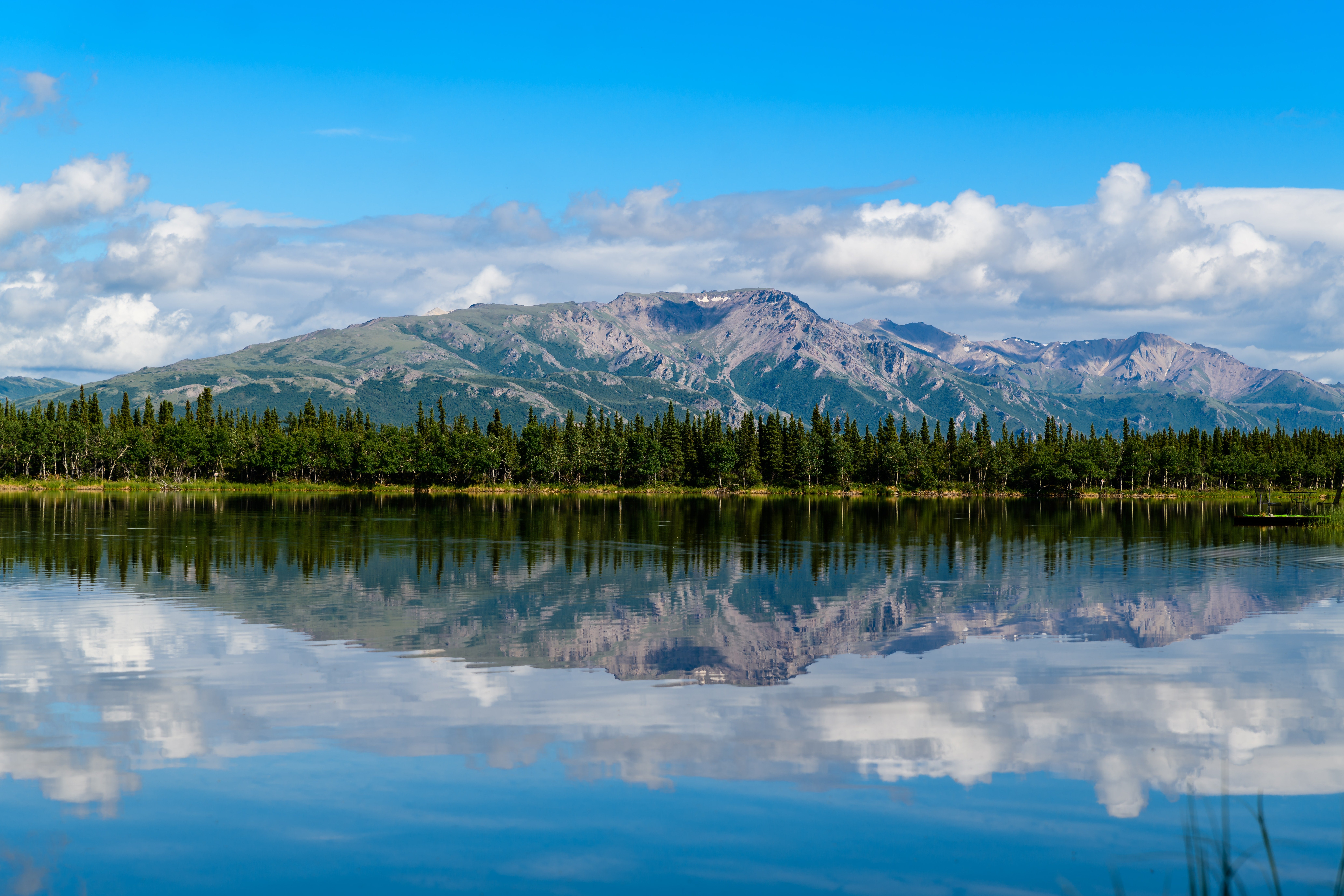 A view of mountains, trees and lake.