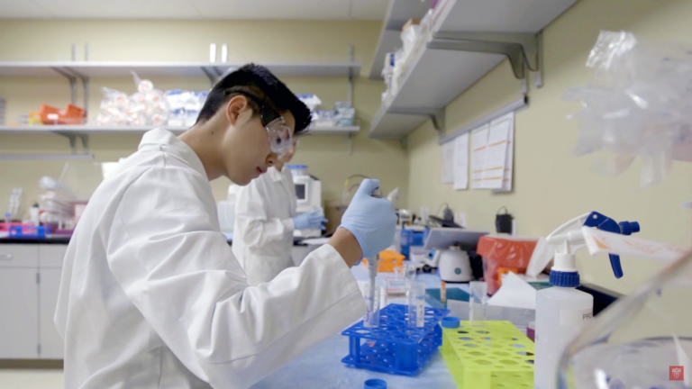 A scientist using a pipette while working in a lab.
