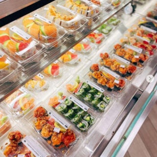 A convenience counter with to-go sushi in cartons.