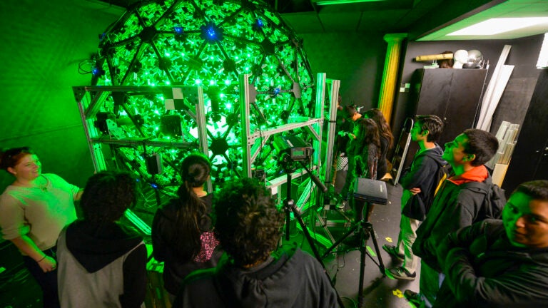 A group of students standing in front of a light stage.