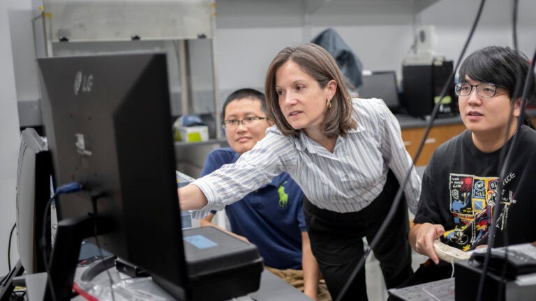 Professor Andrea Armani teaching students in front of a computer
