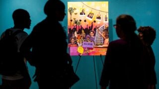 USC students silhouetted view a Black History Month mural.