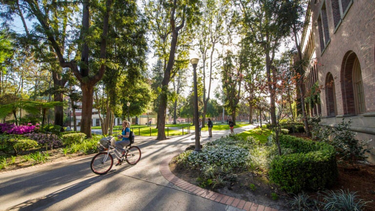 student riding a bike on campus
