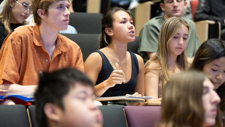 Student speaking during a USC class while classmates and lecturer listen.