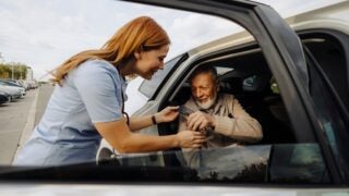 Older person being helped into a car